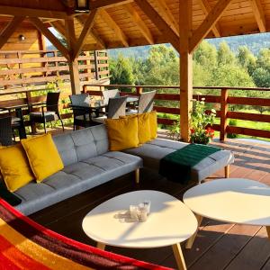 a patio with a couch and two tables at Barnilka House Klimkówka in Klimkówka