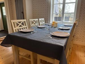 a table with a blue table cloth and glasses on it at Nedanby | Cottage | Idyllic location | Porch | Grill in Edsbro