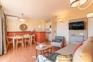 a living room with a couch and a dining room at Village Pierre & Vacances Pont Royal en Provence in Mallemort