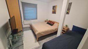 a small room with two beds and a television at Vila MM Boračko jezero in Konjic +25 photos