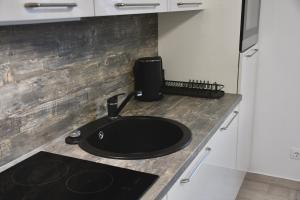 a kitchen counter with a black sink on a counter top at Valuna - Modern Sea View Apartment -Terrace - 4 Min to Beach - Free Parking in Jadranovo
