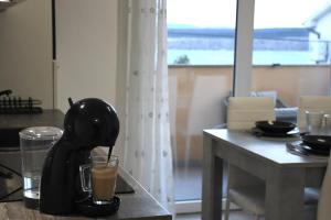 a coffee maker and a glass on a table at Valuna - Modern Sea View Apartment -Terrace - 4 Min to Beach - Free Parking in Jadranovo