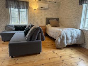 a bedroom with a bed and a couch and a chair at Nedanby | Cottage | Idyllic location | Porch | Grill in Edsbro