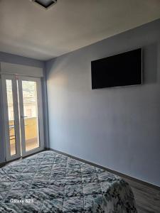 a bedroom with a bed and a television on the wall at Appartamento Torri del Benaco in Torri del Benaco