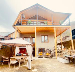 a house with a patio with tables and an umbrella at happy pandasN12 in Borjomi