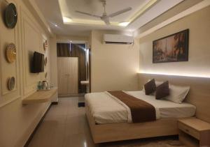 a hotel room with a bed and a television at Hotel Ananta Vilas in Khurja