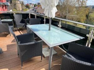 a table with chairs and an umbrella on a balcony at Ferienwohnung Maria mit Elbblick in Coswig