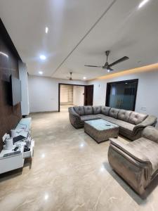 a large living room with couches and a tv at Thecomfortden in Sohāna