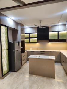 a kitchen with stainless steel appliances and black cabinets at Thecomfortden in Sohāna