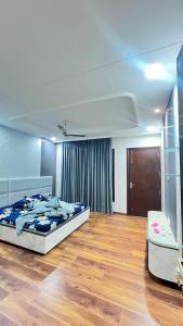 a bedroom with a bed and a wooden floor at Thecomfortden in Sohāna