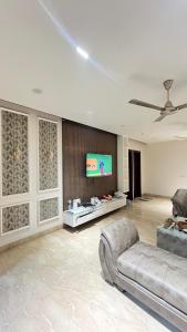 a living room with a couch and a flat screen tv at Thecomfortden in Sohāna