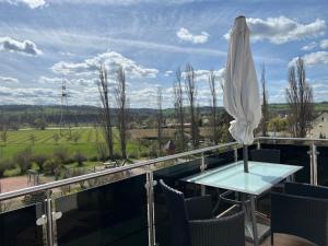 a patio with a table and a white umbrella at Ferienwohnung Maria mit Elbblick in Coswig