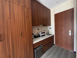 a small kitchen with wooden cabinets and a microwave at D02 - Happy Beach Villas - No2 Căn hộ Z&Z Triple key - NovaWorld Ho tram in Binh Chau