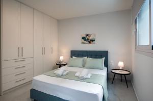 a bedroom with a large bed with two towels at Kamara View Apt 1 in Agios Nikolaos