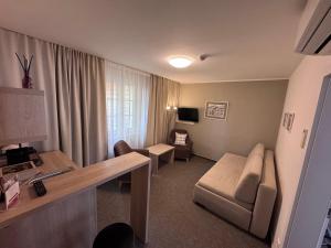 a hotel room with a desk and a living room at Sonjas Auszeit in Rust