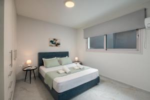 a white bedroom with a large bed and a window at Kamara View Apt 1 in Agios Nikolaos +6 photos