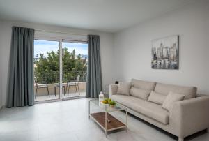 a living room with a couch and a glass table at Kamara View Apt 1 in Agios Nikolaos