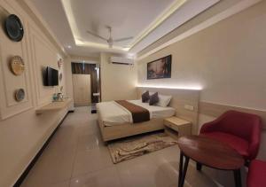 a bedroom with a bed and a chair in it at Hotel Ananta Vilas in Khurja +16 photos