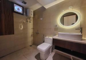 a bathroom with a sink and a toilet and a mirror at Hotel Ananta Vilas in Khurja