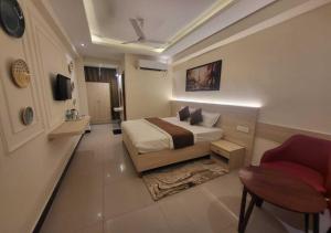 a bedroom with a bed and a couch and a chair at Hotel Ananta Vilas in Khurja