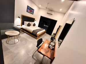 a bedroom with a bed and a table and a chair at Taaffeite Hotels And Resorts in Lonavala