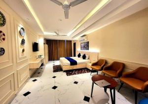 a hotel room with a bed and two chairs at Hotel Ananta Vilas in Khurja