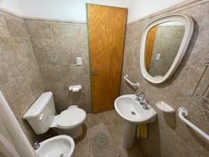 a bathroom with a toilet and a sink and a mirror at Cabañas El Muelle in Cholila