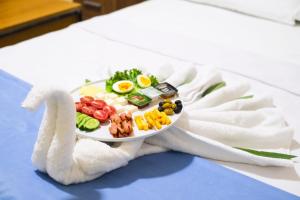 a plate of food on a bed with a towel at Elflora Otel in Ceyhan