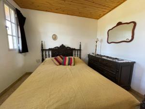 a bedroom with a bed with a dresser and a mirror at Cabañas El Muelle in Cholila