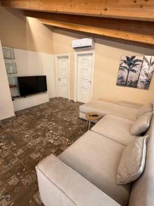 a living room with a couch and a flat screen tv at Sea View Penthouse in Durrës