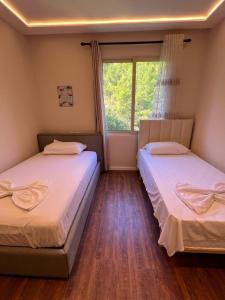 two beds in a room with a window at Sea View Penthouse in Durrës +88 photos