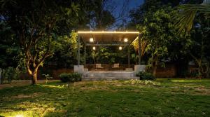 a bench in a park at night with lights at Dharti in Moinabad