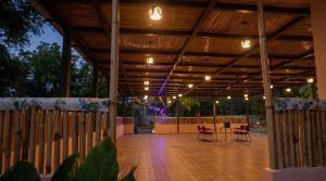 a wooden covered patio with a table and chairs at Dharti in Moinabad