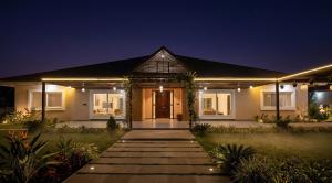 a house with a pathway leading to the front door at night at Dharti in Moinabad