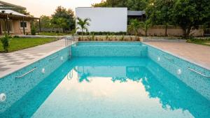 a swimming pool with blue water in a yard at Dharti in Moinabad