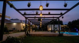 a pergola with potted plants and lights at night at Dharti in Moinabad
