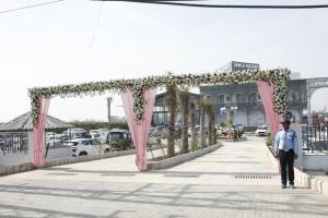 a man walking down a sidewalk with a pink arch at Jawla Resort in Palwal