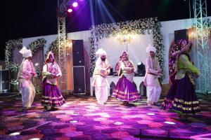 a group of people dancing on a stage at Jawla Resort in Palwal