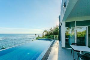 a house with a swimming pool next to the ocean at Iconic Polhena in Matara