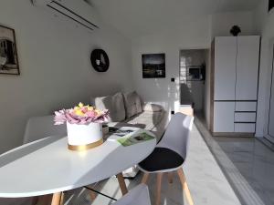 a white living room with a table and chairs at Lake View Terrace Apartment Dapcevic in Vranjina