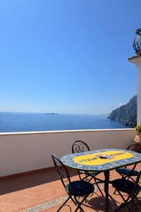 a table and chairs on a balcony with a view of the ocean at Casa Marty in Positano