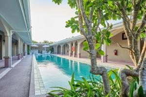a swimming pool next to a building with trees at BARA BARA' Budget SATUN 'SHA Plus' in Satun +119 photos
