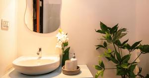 a bathroom with a sink and a vase of flowers at Nivara Stays Lingampalli, A Boutique Hotel Brand in Hyderabad