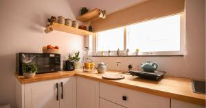 a kitchen with a counter top with a microwave at Nivara Stays Lingampalli, A Boutique Hotel Brand in Hyderabad
