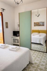 a bedroom with two beds and a large mirror at Casa Marty in Positano