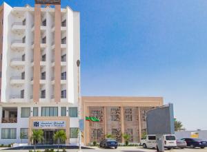 a large white building with cars parked in front of it at SUNSET HOTEL in Nouakchott