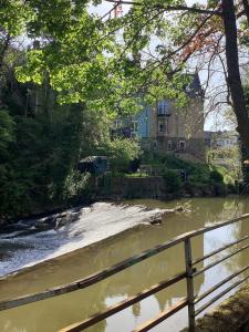 a river with a fence in front of a house at Hilla's Traumhaus in der Eifel in Schleiden