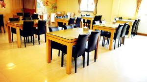 a dining room with wooden tables and chairs at Discovery Motel - Tucheng in Tucheng