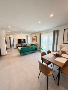 a living room with a green couch and a table at Local-Lux Garden Residence A- 2 Bedrooms-Terrace in Kecskemét
