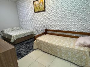 a bedroom with two beds and a wall at Interlagos Family House in São Paulo